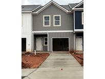 New construction townhome showing a gray and white exterior with a concrete driveway leading to a one-car garage at 9454 Pinecrest Path # 315, Jonesboro, GA 30238