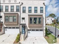 Modern townhome with a white brick facade, bay windows, and a one car garage at 2171 Burnside Dr Nw, Atlanta, GA 30318