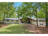 Charming single-story home with a lush lawn, mature trees, and a welcoming front facade at 5785 Timberlane Ter, Sandy Springs, GA 30328