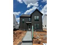 New construction two-story home featuring board siding, black window frames, and a sidewalk leading to the front door at 3472 Adler Trl, Buford, GA 30519