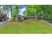 Charming single-story home featuring a stone facade, blue accents and a well manicured lawn with beautiful landscaping at 5742 Harbor Dr, Buford, GA 30518