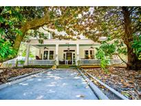Charming two-story home featuring a classic front porch with white pillars, fans, and decorative railings at 8612 Campbellton St, Douglasville, GA 30134