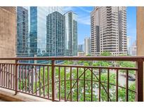 View from balcony showing steel railing and city skyscrapers beyond green trees at 1101 Juniper Ne St # 919, Atlanta, GA 30309