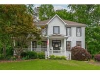 Charming two-story home boasts a welcoming front porch and professionally landscaped yard at 1161 Arborhill Dr, Woodstock, GA 30189