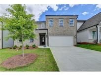 Charming two-story brick home with an attached two-car garage and newly planted front yard at 3968 Annsbury Court, Lilburn, GA 30047