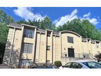 A multi-story apartment building with brick facade and ample tree coverage surrounding the building at 5400 Roswell Rd # L-3, Atlanta, GA 30342