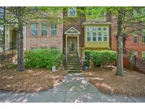 Charming townhome featuring a brick facade, lush landscaping, and a welcoming entrance at 62 High Top Pt, Sandy Springs, GA 30328