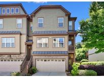 Three story townhouse with attached garage and neutral colored siding at 702 Emeril Dr, Avondale Estates, GA 30002