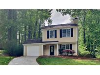 Charming two-story home with a well-maintained lawn and a paved driveway leading to a single-car garage at 829 Longfellow Ct, Stone Mountain, GA 30088