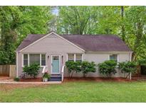 Charming single-story home featuring a freshly painted brick exterior, new landscaping, and a bright turquoise front door at 2599 E Tupelo Se St, Atlanta, GA 30317