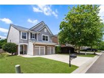 Charming two-story home with a well-manicured lawn, two-car garage, and a beautiful mature tree in the front yard at 5830 Sterling Ct, Cumming, GA 30040
