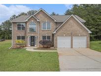 Charming two-story brick home with a well-manicured lawn and an attached two-car garage at 1024 Odelle Cir, Mcdonough, GA 30253
