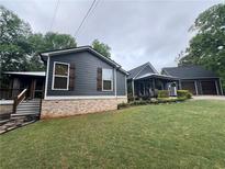 Charming home with dark siding, brick foundation, and a spacious lawn at 284 Harris Loop, Dallas, GA 30157