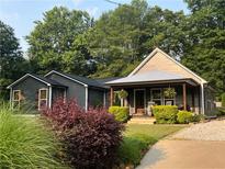 Charming home featuring a covered porch, manicured landscaping, and inviting curb appeal at 284 Harris Loop, Dallas, GA 30157