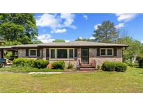 Charming brick home with well-kept lawn, trimmed bushes, and a covered car port at 2365 Fontaine Cir, Decatur, GA 30032