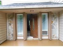 Inviting front entryway with a beautiful wood door, sidelight windows, and stone facade accents at 2926 Swarthmore Dr, Lawrenceville, GA 30044