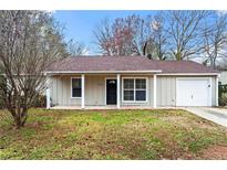 Charming single-story home with a well-maintained lawn and a cozy front porch at 1056 Park West Ct, Stone Mountain, GA 30088