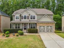 Charming two-story home featuring a stone-accented garage and well-manicured front yard at 4545 Evandale Way, Cumming, GA 30040