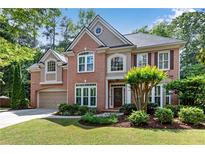 Charming two-story brick home with well-manicured lawn, lovely landscaping, and attached two car garage at 486 Milledge Gate Se Ter, Marietta, GA 30067
