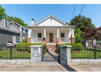 Charming cottage-style home featuring a well-manicured front yard with beautiful landscaping and brick-accented porch at 69 Randolph Ne St, Atlanta, GA 30312