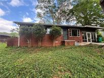 Cozy one-story brick home featuring a screened-in porch, mature trees, and a well-maintained lawn at 2069 Bixler Circle, Decatur, GA 30032