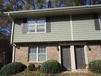 Townhouse exterior featuring a brick facade and shake siding under the windows at 31 Villa Se Ct, Smyrna, GA 30080