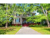 Attractive two-story house with lush green trees, a welcoming porch, and a well-maintained lawn at 30 Sessions Nw St, Marietta, GA 30060