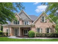 Charming two-story brick home with a welcoming front porch and well-manicured landscaping at 448 Cape Ivey Dr, Dacula, GA 30019