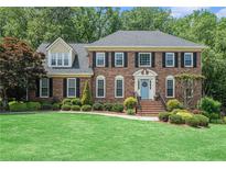 Charming two-story brick home featuring a well-manicured lawn and inviting blue front door at 751 Yorkshire Sw Pl, Lilburn, GA 30047