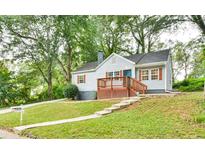 Charming home with a well-manicured lawn, inviting front porch, and quaint architectural details at 1626 Oak Knoll Se Cir, Atlanta, GA 30315