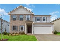 Charming two-story home with a brick facade, gray shutters, well-manicured lawn, and an attached two-car garage at 340 Paulownia Cir, Mcdonough, GA 30253