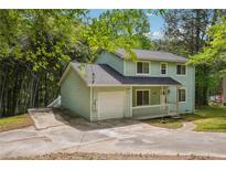 Charming two-story home with light green siding, covered porch, and a well-maintained front yard at 3688 Burnley Court, Lithonia, GA 30038