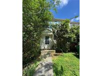 Quaint two-story home with overgrown landscaping and a traditional white front door at 3739 Jamestown Ct, Doraville, GA 30340