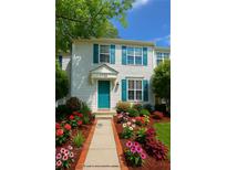 Charming townhouse featuring colorful flower beds, a blue door and shutters, and beautiful curb appeal at 3739 Jamestown Ct, Doraville, GA 30340