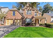 Charming brick home with a two-car garage and a well-manicured front lawn at 4840 Shiloh Springs Rd, Cumming, GA 30040