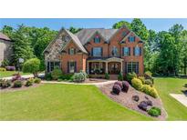 Beautiful two-story brick home with a well-manicured lawn and professional landscaping at 5925 Boulder Bluff Dr, Cumming, GA 30040