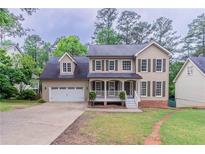 Charming two-story home with a manicured front yard and a two-car garage at 1912 Riverton Dr, Suwanee, GA 30024