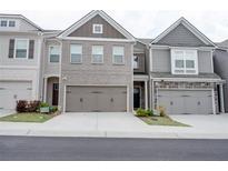 Townhome exterior showcasing the building's facade, garages, and well-maintained landscaping at 7621 Avalon Blvd, Fairburn, GA 30213