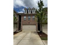 Beautiful brick townhome features a two-car garage and well-maintained landscaping at 4858 Stratford Ln, Johns Creek, GA 30022