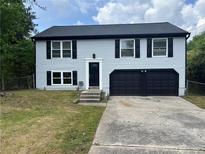 Charming two-story home with blue siding, black shutters and a spacious two-car garage at 1185 Jocelyn Ct, Stone Mountain, GA 30088