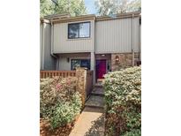 Charming townhome featuring a stone facade, a vibrant red door, and beautifully landscaped entryway at 1205 Druid Knoll Ne Dr, Brookhaven, GA 30319