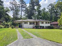 Charming single story home with a well-manicured lawn, mature trees, and a driveway at 217 Penelope Nw Dr, Atlanta, GA 30314