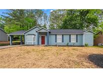 Charming one-story home featuring light blue siding, a red front door, and a well-manicured front yard at 7629 Park Ln, Jonesboro, GA 30236