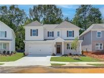 Charming two-story home featuring a white brick facade, well-manicured lawn, and inviting curb appeal at 3672 Silvery Way, Powder Springs, GA 30127