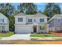 Beautiful new two-story home featuring a white brick facade, attached garage, and well-maintained landscaping at , Powder Springs, GA 30127