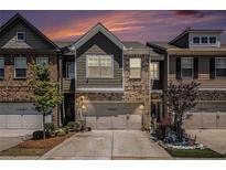 Charming townhome featuring a two-car garage and a beautifully landscaped front yard at 2404 Fitts Dr, Conyers, GA 30094