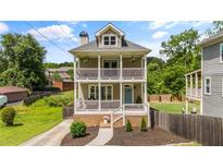 Charming two-story home with a double porch, white railings, and landscaped front yard at 925 Hill Se St, Atlanta, GA 30315