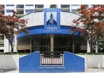 Building entrance with blue facade, manicured greenery, and prominent signage at 1130 Piedmont Ne Ave # 410, Atlanta, GA 30309
