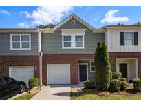 Charming townhome featuring a brick facade, attached garage, and manicured landscaping at 1881 Millstream Holw, Conyers, GA 30012