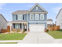 Charming two-story home with blue siding, a well-manicured lawn, and a two-car garage at 108 Berwick Crossing, Dallas, GA 30157